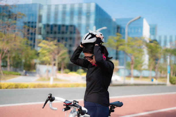 Beginner cyclist adjusting helmet before a practice ride